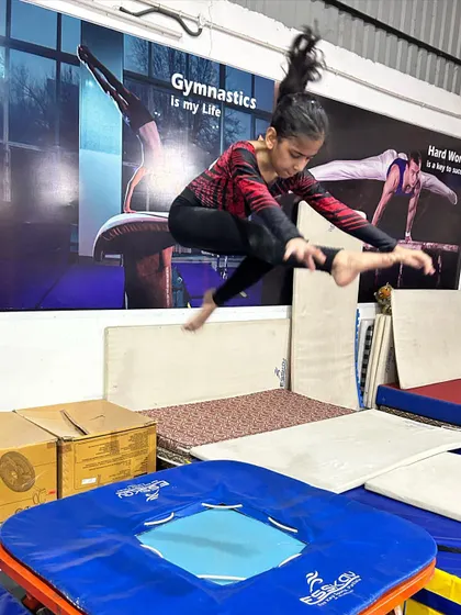 A young gymnast practices a jump on the mini-trampoline, a tool we use to develop explosive leg power for tumbling and vaulting.