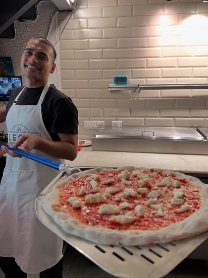 Our head pizzaiolo, Amol, with a fresh pizza ready to go into the oven. This is where the passion for pizza begins.