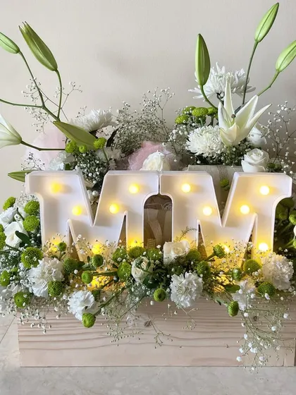 Embracing the beauty of white blooms with this specially curated gift hamper for a design school. The light-up 'MM' initials for Manish Malhotra add a personalized and celebratory touch.