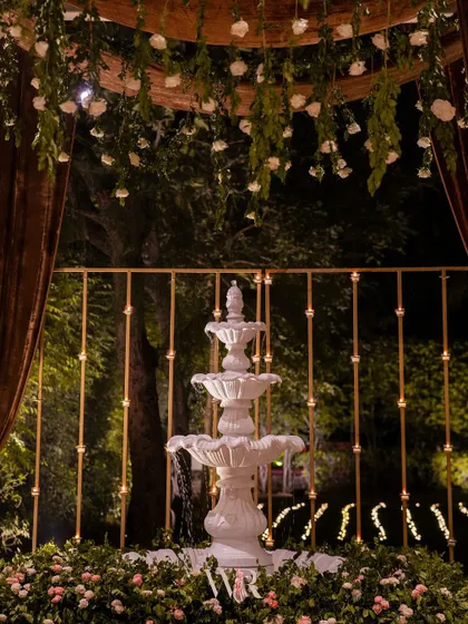 A beautiful white water fountain serves as a serene centerpiece, surrounded by a bed of pink and white flowers. The sound of water added a calming sensory element to the event.