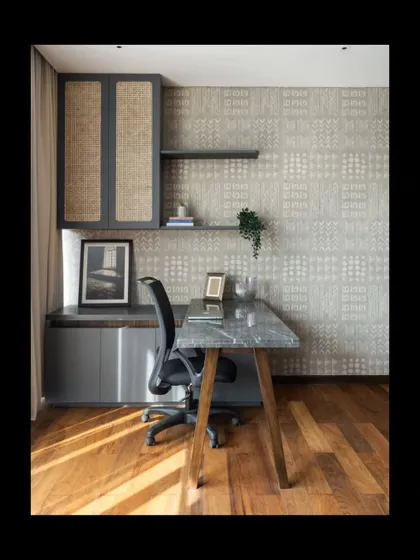 We designed this home office to be a space of quiet focus. A custom marble-topped desk is paired with cane-fronted cabinetry and a subtly patterned wallpaper. The interplay of natural wood floors, stone, and woven textures creates a tactile and inspiring work environment.
