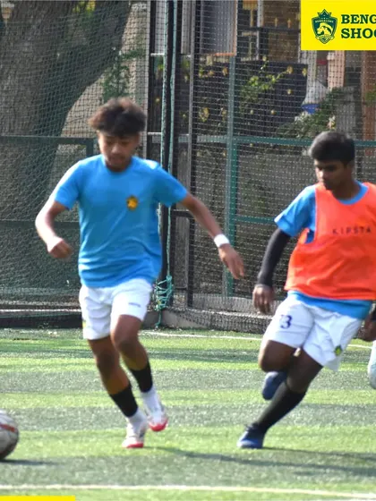 A young player skillfully dribbles the ball under pressure from a defender during an intra-academy practice match between our Whitefield and TC Palaya teams.