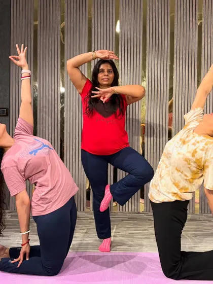 Finding balance and focus in a group setting. This photo captures a beautiful moment from a yoga class, with students holding different asanas like Tree Pose (Vrikshasana) and a kneeling backbend.