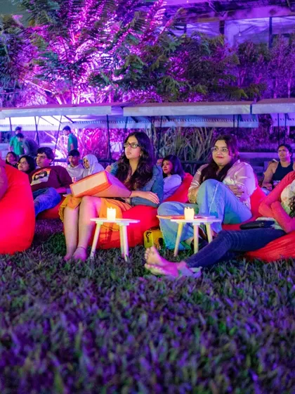 Guests engrossed in the movie during a sunset screening, with candles adding to the cozy ambiance.