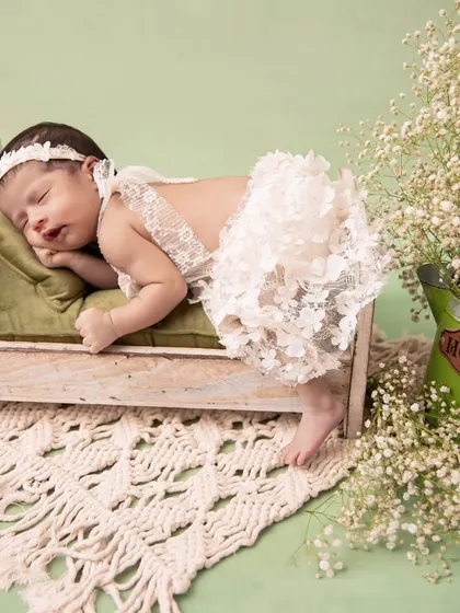 One prop, many possibilities. Here, a baby in a delicate lace outfit sleeps peacefully on her tummy on a miniature bed, creating a sweet and angelic portrait.