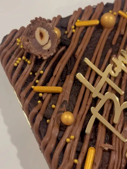 A detailed shot of the Ferrero Rocher brownie cake, showing the rich texture and toppings. It's a chocolate lover's dream come true.