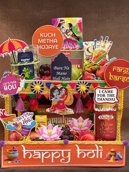 Bringing a *rangeen* blast to your Holi celebrations! This hamper is designed to look like a vibrant street stall, packed with fresh fruits, thandai, gujia, and fun props like water guns and colors to get the party started.