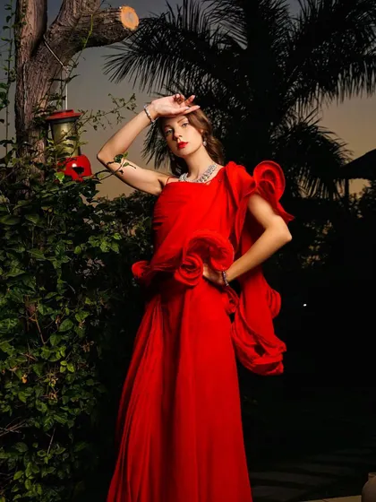 A full-length shot of the red gown, capturing a high-fashion pose that feels both elegant and powerful.