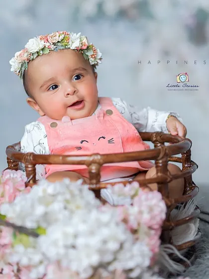 This studio setup combines rustic props with soft, delicate florals to create a beautiful and happy portrait for a baby girl.