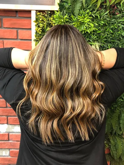The back view of this blonde balayage shows the incredible dimension and texture created by the hand-painted highlights.