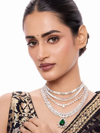 This look is for the modern woman who loves glamour. A stunning multi-layered diamond-look necklace with a bold emerald drop, it’s designed to make a statement at your cocktail party or reception.