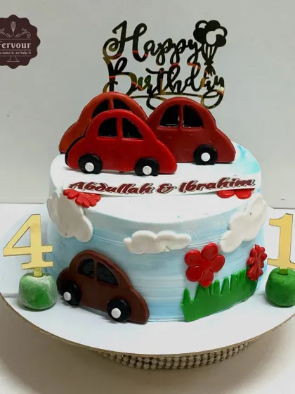 Another fun car-themed cake, this one celebrating a joint 1st and 4th birthday. It features red and brown cars on a sky-blue cake with a "Happy Birthday" topper.