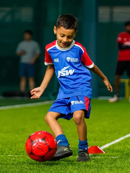 A smile on his face, a young player enjoys a dribbling exercise. We believe that learning happens best when players are having fun.