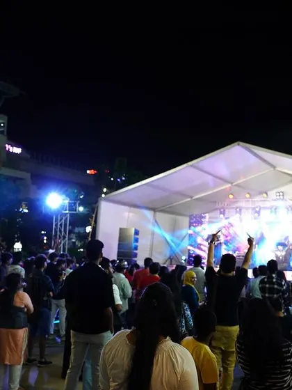 The view from the back of the crowd, showing our full stage setup under a large tent at Forum South Bengaluru. We can turn any open space into a professional concert venue.