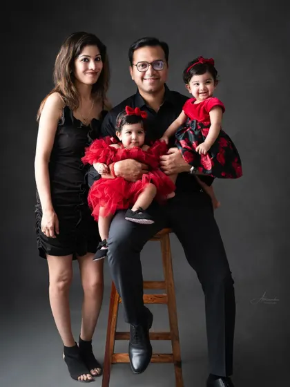 A classic family pose, with dad holding both his twin daughters, creating a beautiful, balanced portrait.