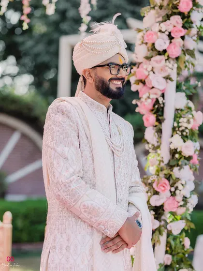 The groom's happy and expectant expression as he waits for his bride at the mandap, a wonderful candid moment from the wedding day.