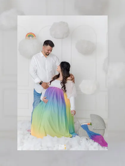 A tender moment between expectant parents amidst a dreamy cloud set. The soft lighting and whimsical props add a touch of magic to this beautiful maternity portrait.