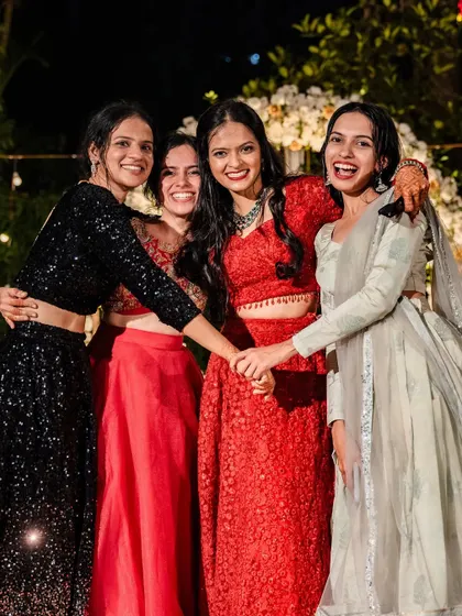The bride and her friends share a laugh and a hug at the reception, a beautiful moment of friendship and celebration.