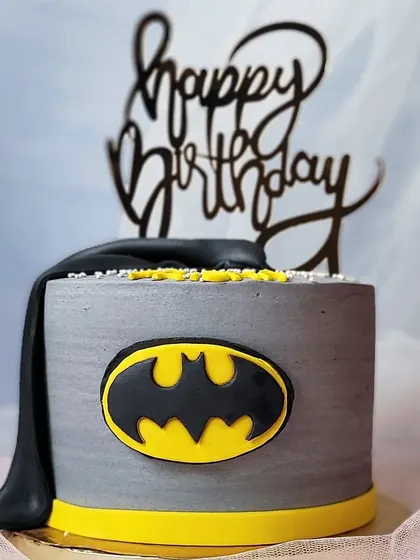 A simple yet striking Batman cake. The grey marbled buttercream and iconic bat symbol create a cool, modern look for a superhero fan.