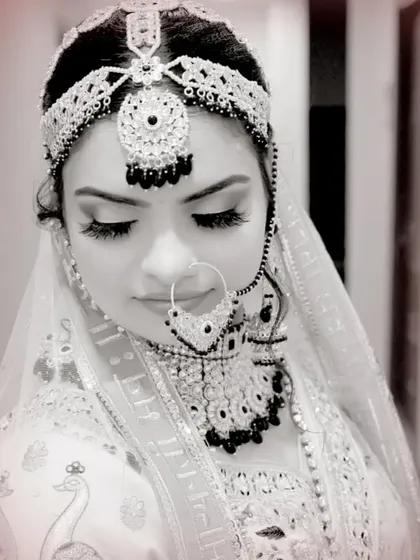 A stunning black and white portrait of a bride, emphasizing her intricate jewelry and delicate features.