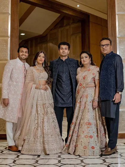 A beautiful family portrait that captures the harmony of our styling. The soft blush and beige tones of the bride, groom, and mother are elegantly contrasted by the deep blue ensembles of the father and brother. This thoughtful color coordination ensures every family photo is a masterpiece.