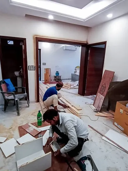 A snapshot of our team at work on-site. This image shows carpenters assembling custom furniture inside a home, demonstrating our hands-on approach to execution and attention to detail during the construction phase.