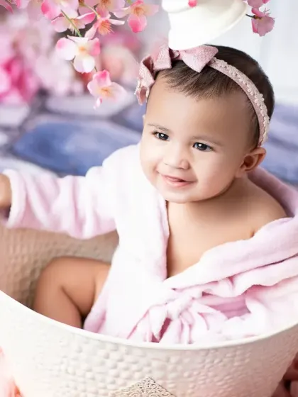A close-up of a happy six-month-old baby during her sitter session. This age is full of sweet smiles and budding personality, perfect for capturing in photos.
