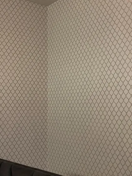 Another angle of the bedroom with the geometric trellis wallpaper.
