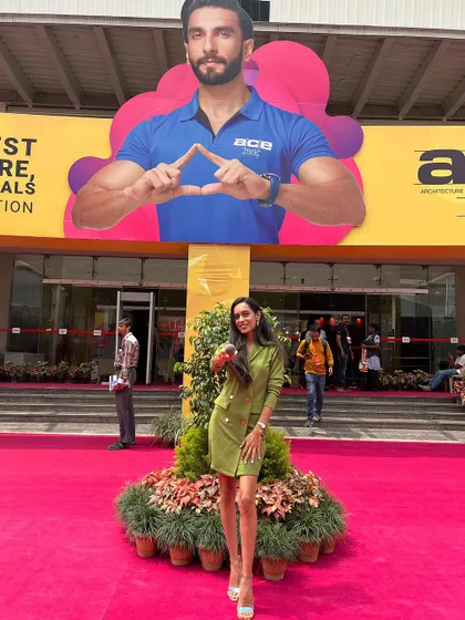 At the entrance of the ACETECH exhibition in Bengaluru, with a larger-than-life cutout of Ranveer Singh. It's all about capturing the grand scale and excitement of major industry events.
