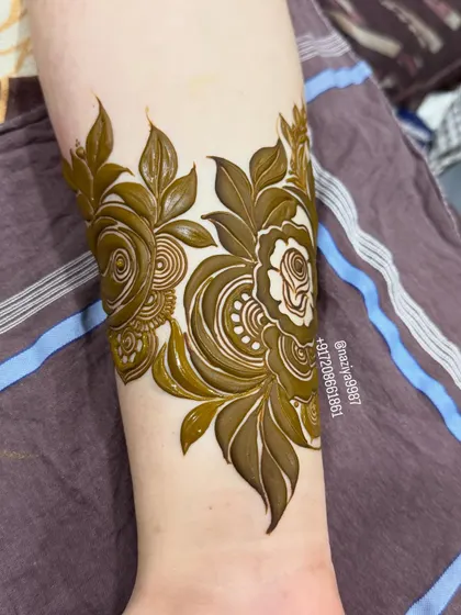 A detailed floral arm band, perfect for adding a touch of henna art without committing to a full-hand design.