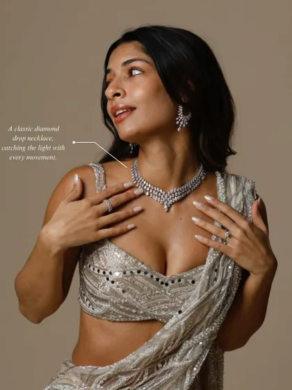 A classic diamond drop necklace catches the light with every movement, making it a stunning choice for a reception or cocktail event. Here, it is styled to perfection, showing its brilliant sparkle.