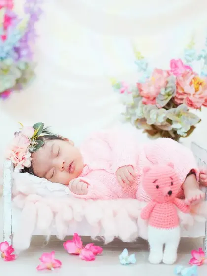 A classic newborn portrait in a miniature bed, surrounded by flowers. This setup makes it look like your baby is a tiny fairy sleeping in a garden.