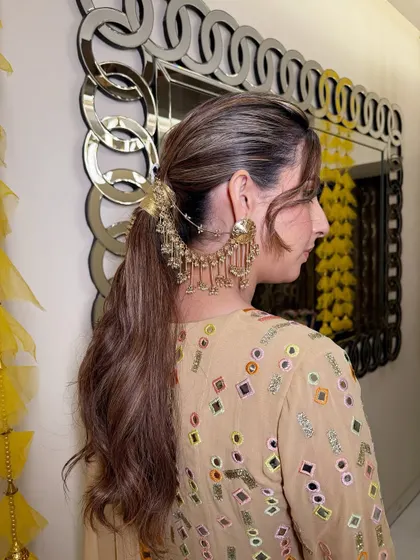 A side view of the textured ponytail, showing how the hair accessory connects to the earrings for a cohesive and unique look.