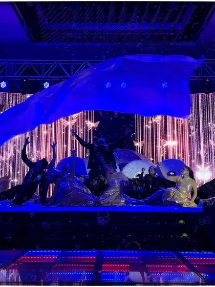 A dramatic moment from the bride's solo, using a large blue fabric prop to create a stunning visual effect.