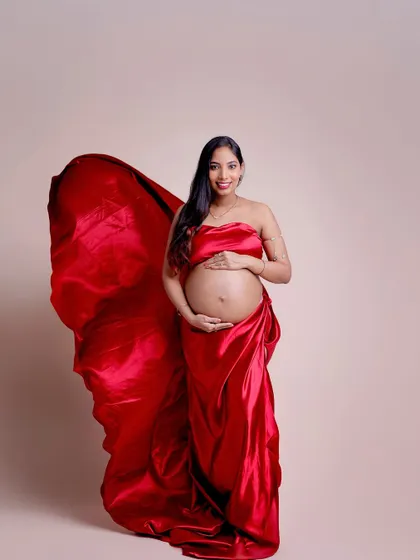 For a bold and artistic look, we offer fabric-wrapping sessions. This portrait uses flowing red satin to create a dramatic and sculptural effect.