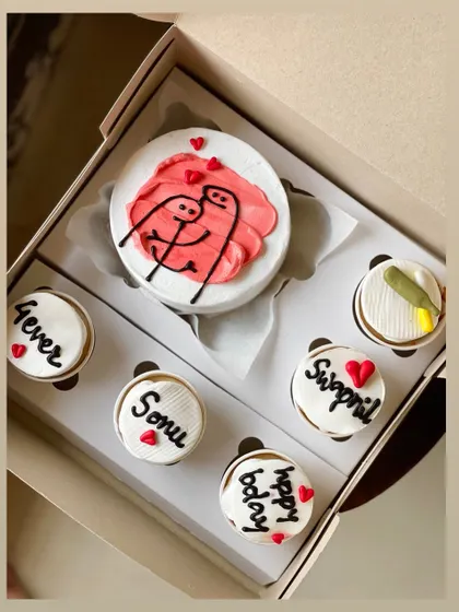 This adorable combo celebrates love with a bento cake showing two stick figures hugging, surrounded by five cupcakes. The cupcakes are personalized with names like 'Sonu' and 'Swapnil' and messages like '4ever' and 'happy bday'.