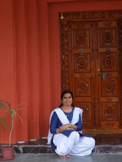 A resident enjoying the traditional `thinnai` or veranda space at the entrance. We design these spaces to encourage informal seating and community interaction, a hallmark of South Indian homes.
