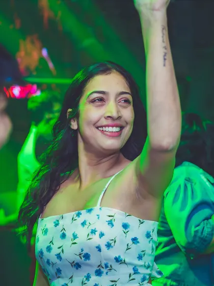 A smiling guest enjoying the green-lit dance floor.