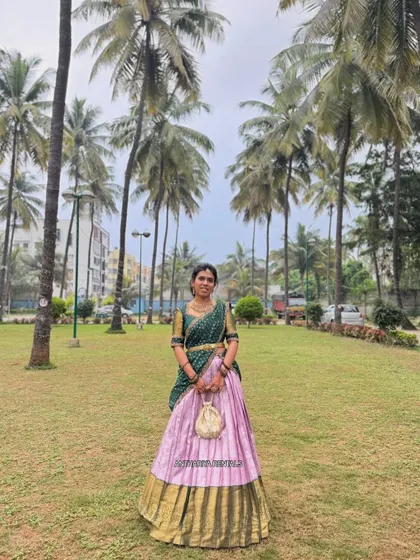A client enjoying her special day outdoors in my green and lavender silk half saree. The outfit's colors stand out beautifully against the natural background.