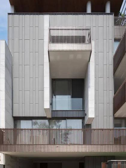The interplay of solid stone volumes and recessed glass creates a dynamic and modern elevation. This approach allows for privacy while maximizing natural light within the home's interior spaces.