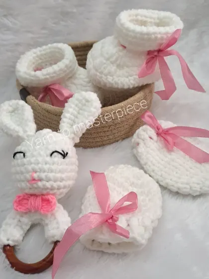 This is my classic newborn gift hamper, a perfect welcome-home present. It features a pair of soft booties, matching no-scratch mittens, and an adorable bunny rattle, all handmade with baby-safe yarn and presented in a reusable basket.