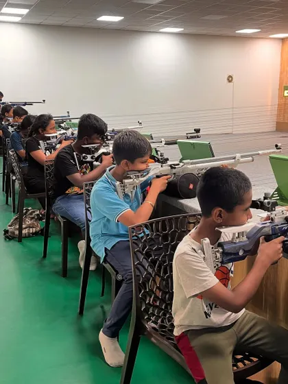 Students practice shooting from a seated position. This technique is valuable for building stability and adaptability, key skills for any marksman.