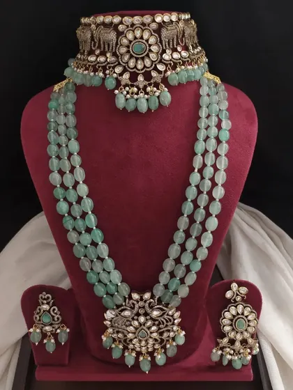 A delicate Victorian set in pastel green with elephant and floral motifs. The matching choker, long necklace, and earrings create a cohesive and elegant look.