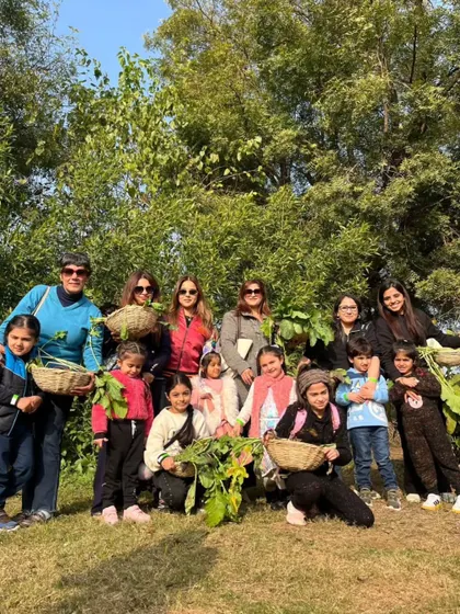 A happy group of mothers and children posing together in the fields with their bountiful harvest.