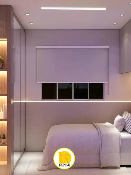 This view highlights the clever use of a mirrored wardrobe and integrated display shelving to make the small room feel more spacious and personalized.