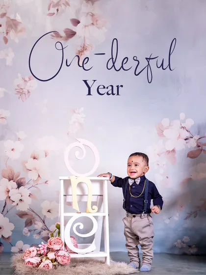 Standing tall and proud to be one! This little boy's charming smile and dapper outfit are the centerpiece of this beautifully simple and elegant first birthday portrait.