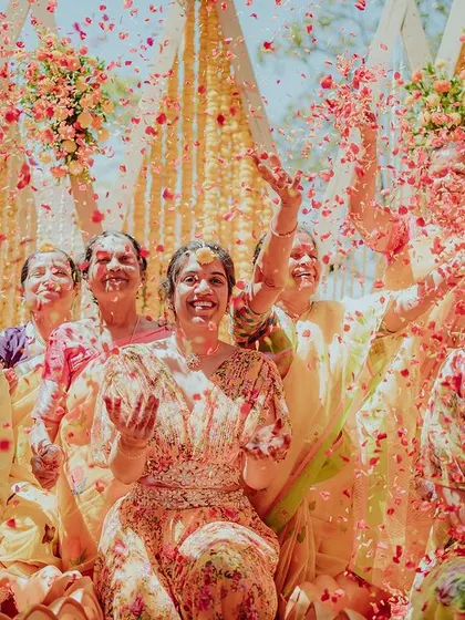 The pure magic of a petal shower during the Haldi ceremony. The air is filled with colorful petals, creating an unforgettable moment of joy and celebration for the couple and their loved ones.