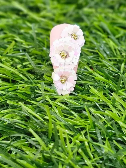 A single, elegant 3D sequin flower design. This is a great way to add a touch of glamour to a manicure without being overwhelming.