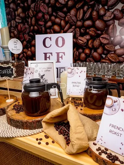 A detailed shot of the coffee tasting station. We used rustic wood slices, glass jars of beans, and clearly labeled cards for different roasts like "French Roast" to create an informative and aromatic experience.