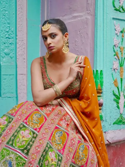 A closer look at the vibrant, multi-colored paneled lehenga. The gota patti work and contrasting colors make it a stunning piece for a Mehendi function.
